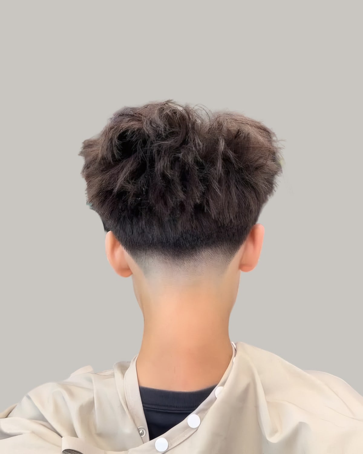 Man with a textured top and a fade, seen from behind
