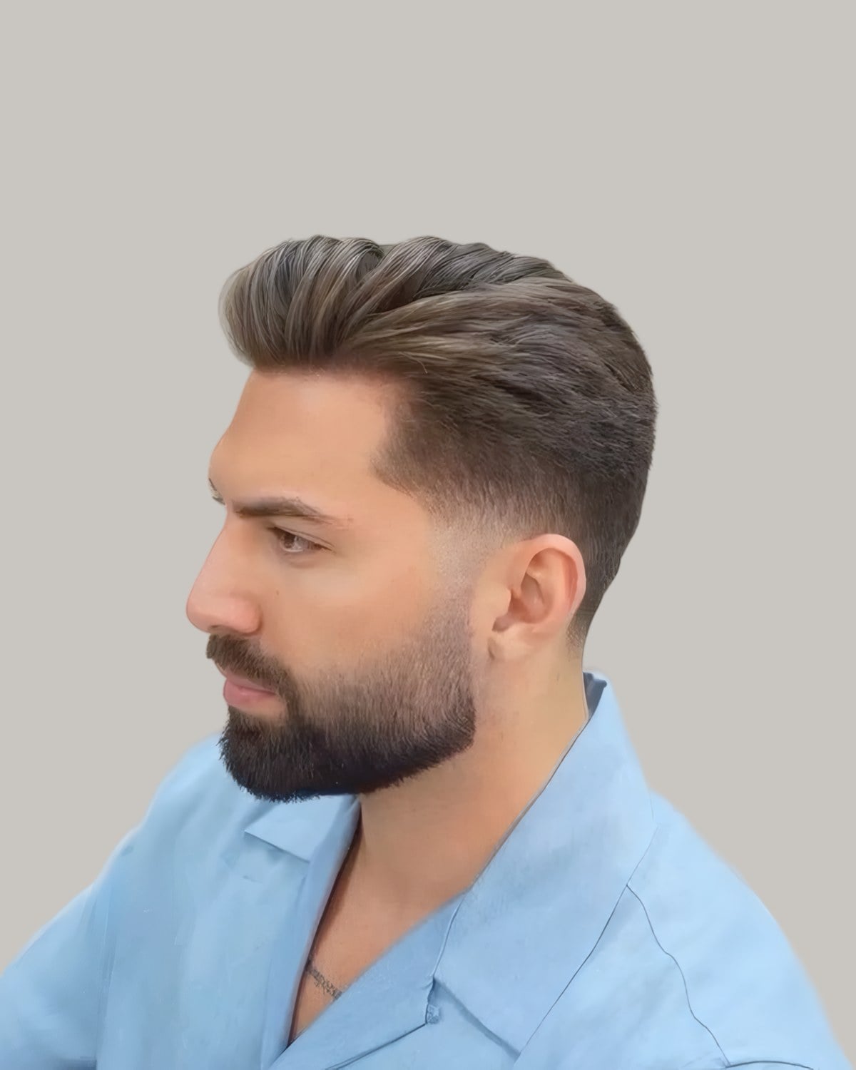Bearded man with a lifted top and a fade, seen in profile