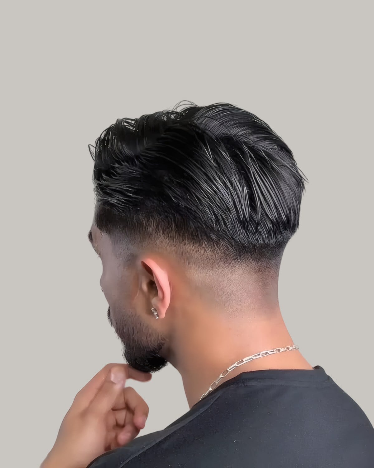Man with a slicked textured top and fine fade, seen from behind