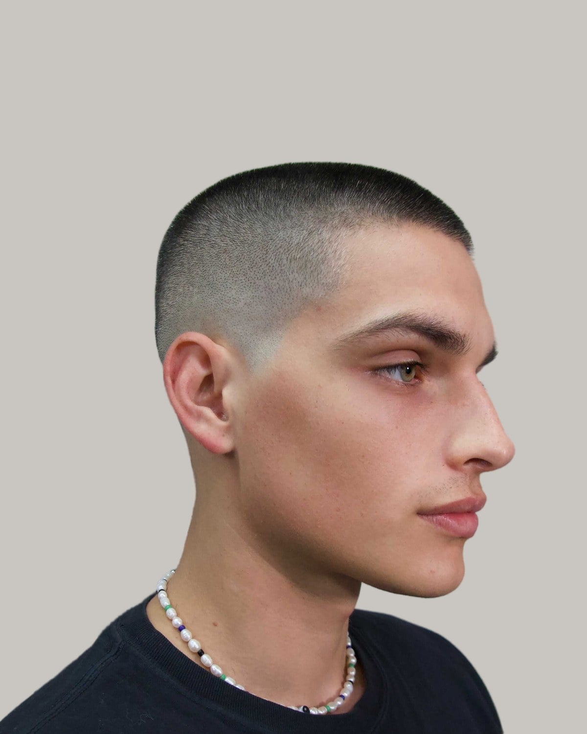 Young man with a very short cut and skin-close sides, seen in profile