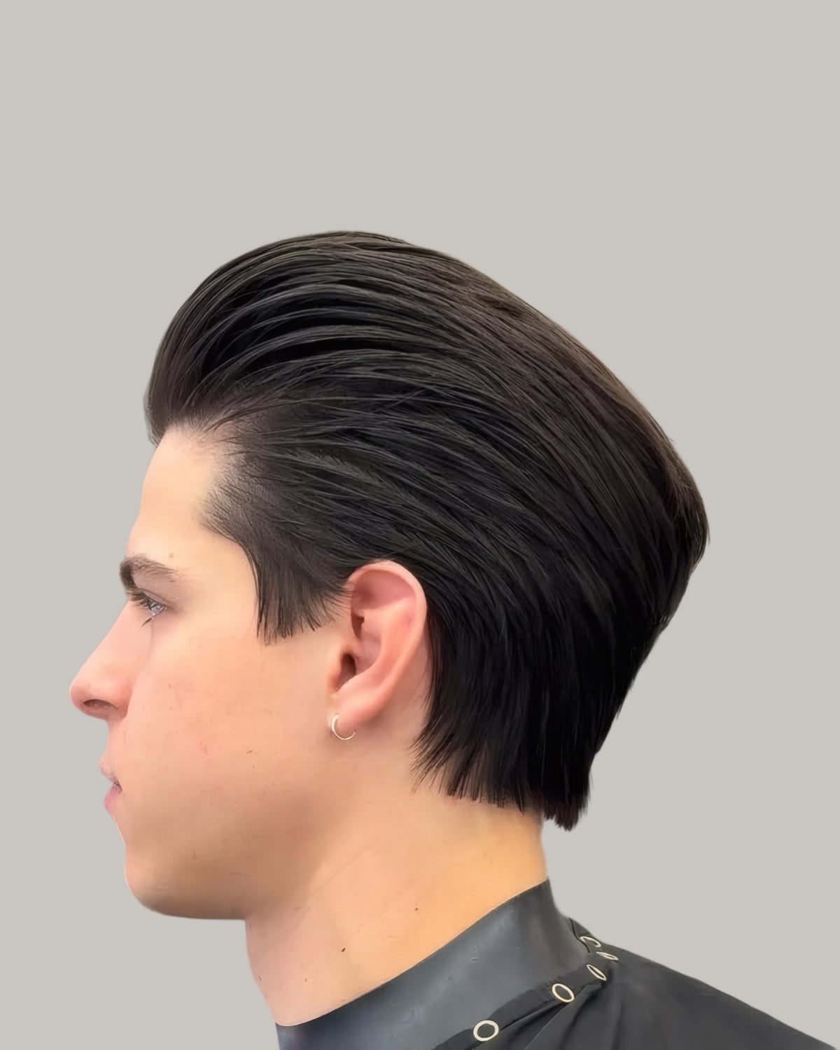 Young man with long slicked-back hair, seen in profile