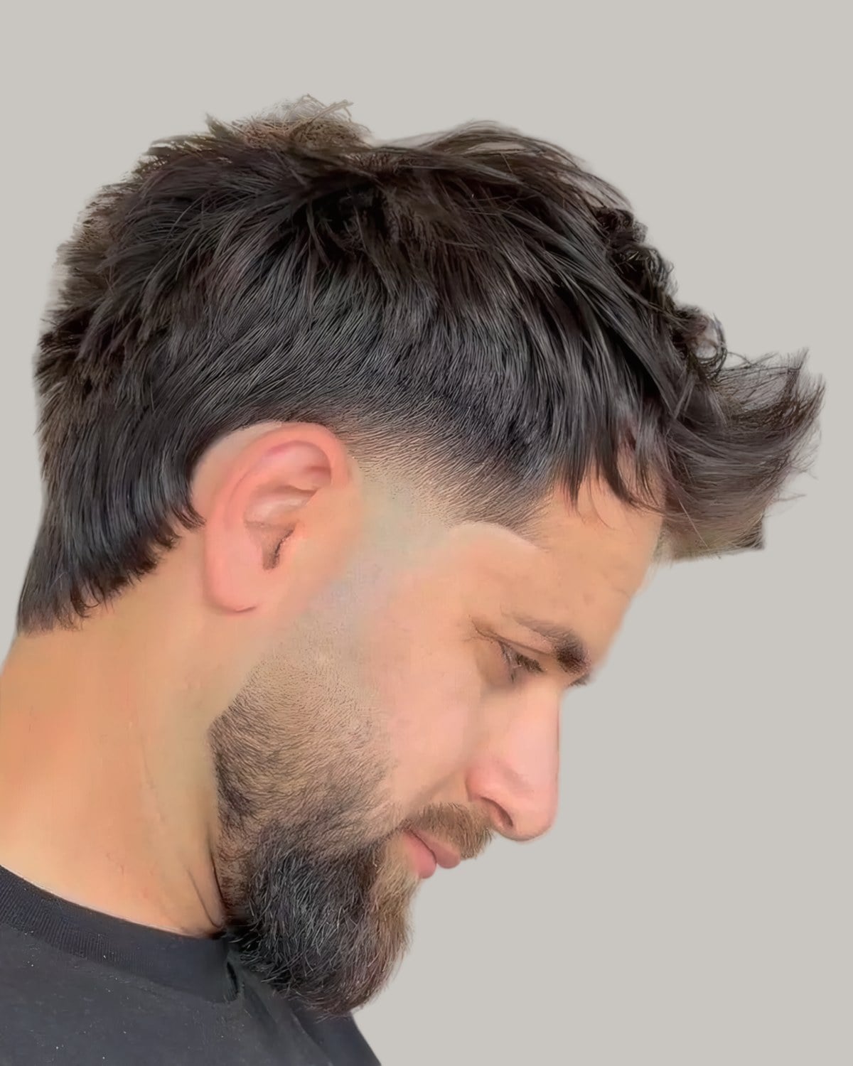 Man with a textured top pushed forward and a taper, looking down