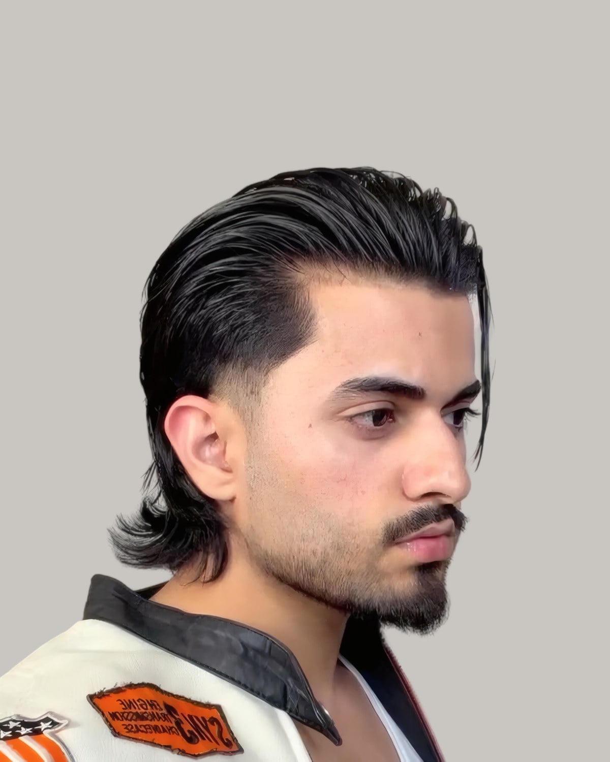 Man with long slicked-back hair and a taper, seen at an angle