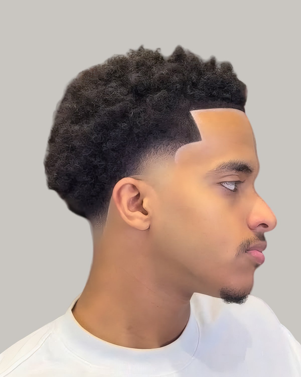Man with a curly top and a sharp temple line, seen in profile