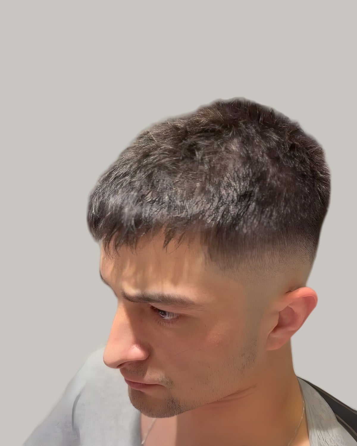 Man with a textured crop and a fade, looking down