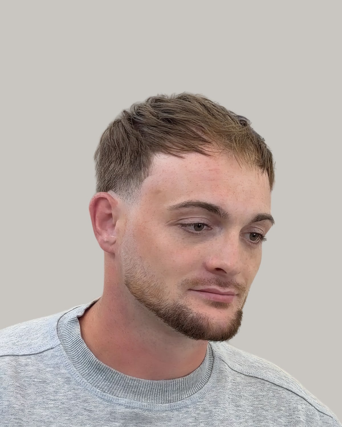 Man with a short textured top and a fade, seen from the front