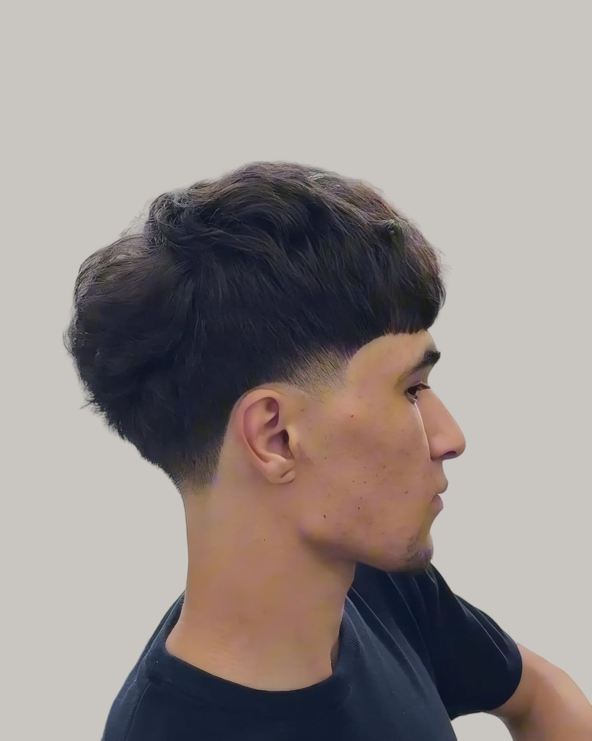 Man with a dark French crop and a low taper, seen in profile