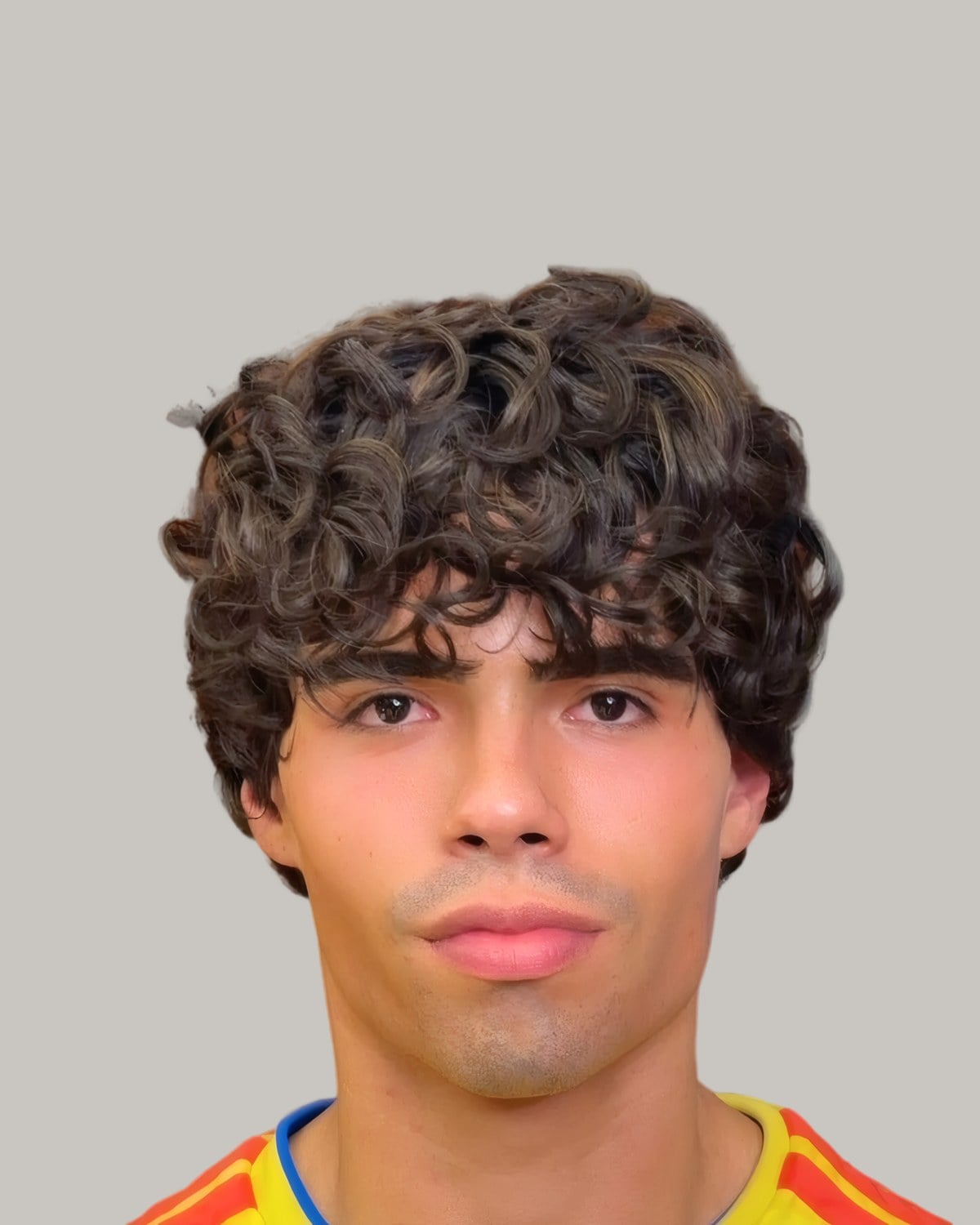 Man with a long curly crop falling over his forehead, facing the camera