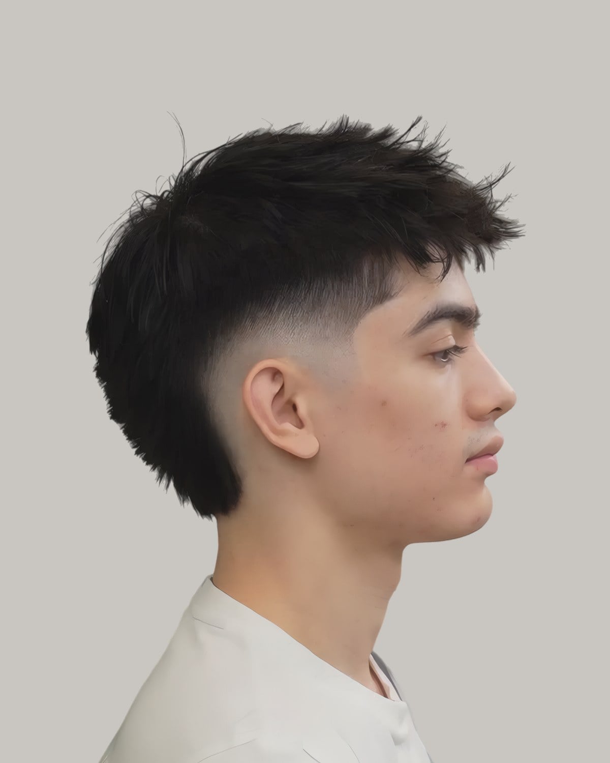 Young man with a textured fringe and a burst fade, seen in profile