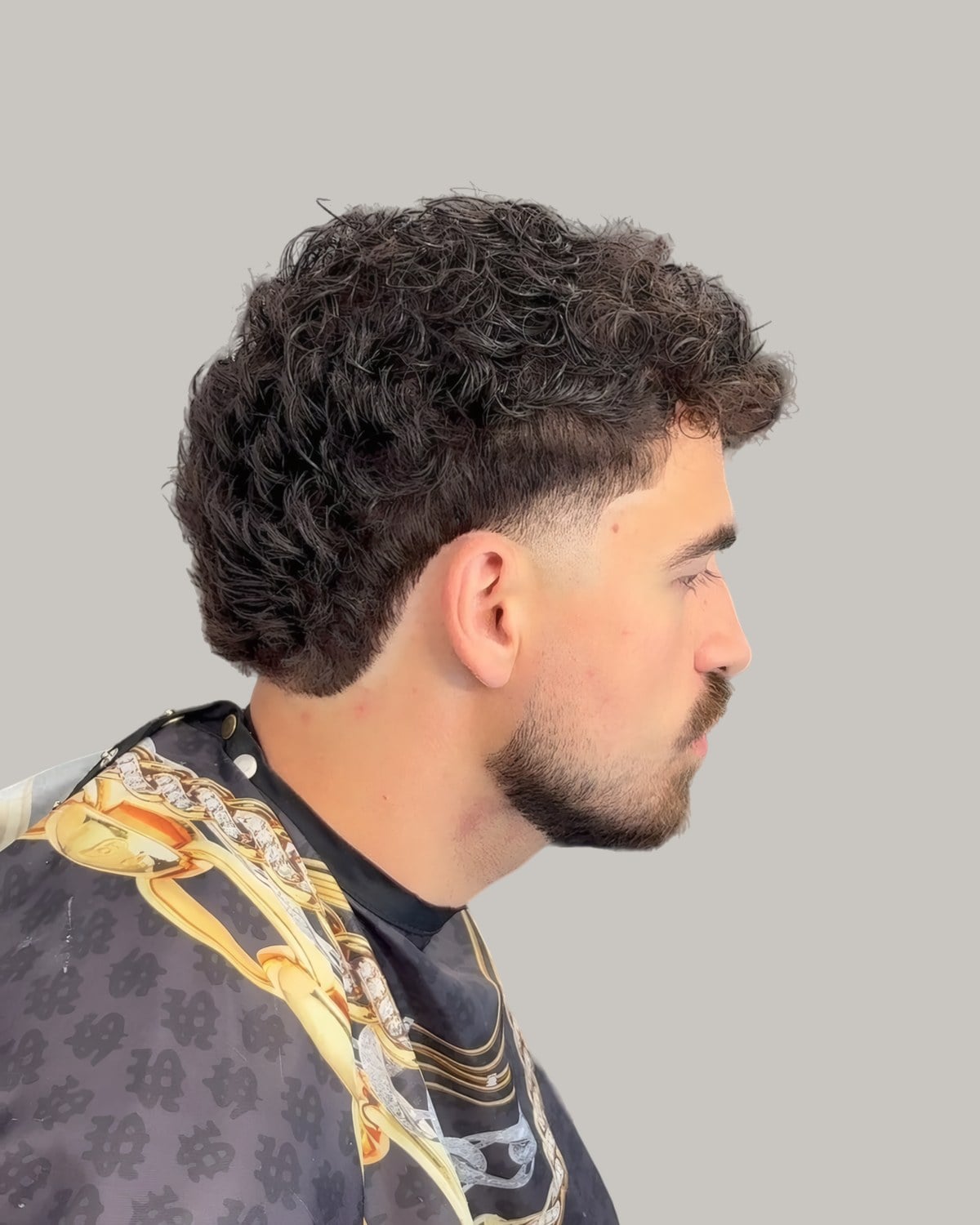 Bearded man with a curly textured top, seen from the side