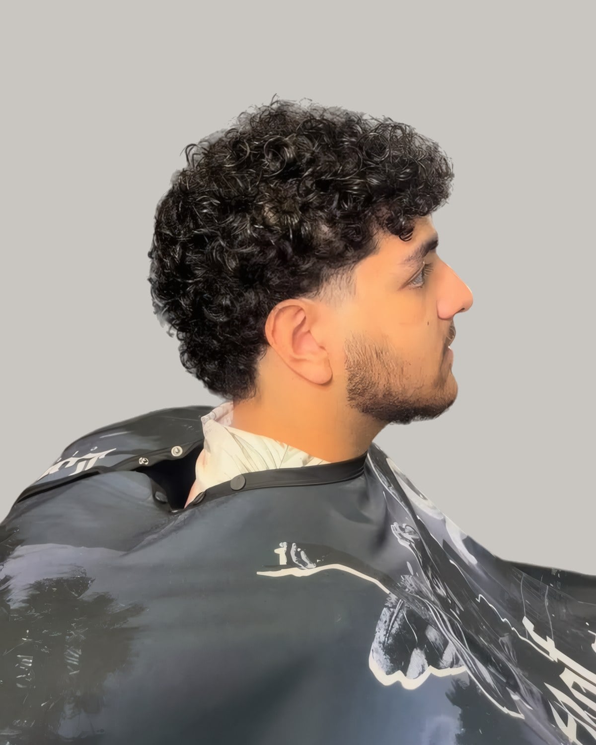 Bearded man with a curly textured fringe, seen from the side