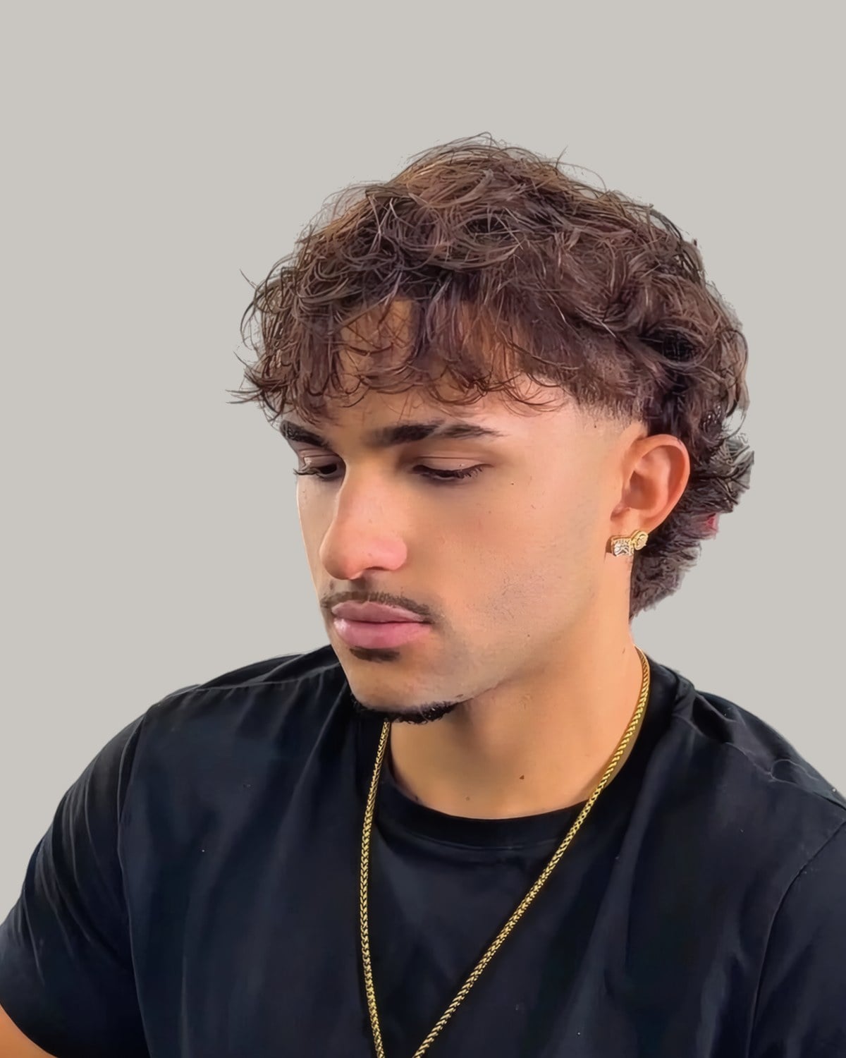 Young man with a brown curly fringe falling onto his forehead