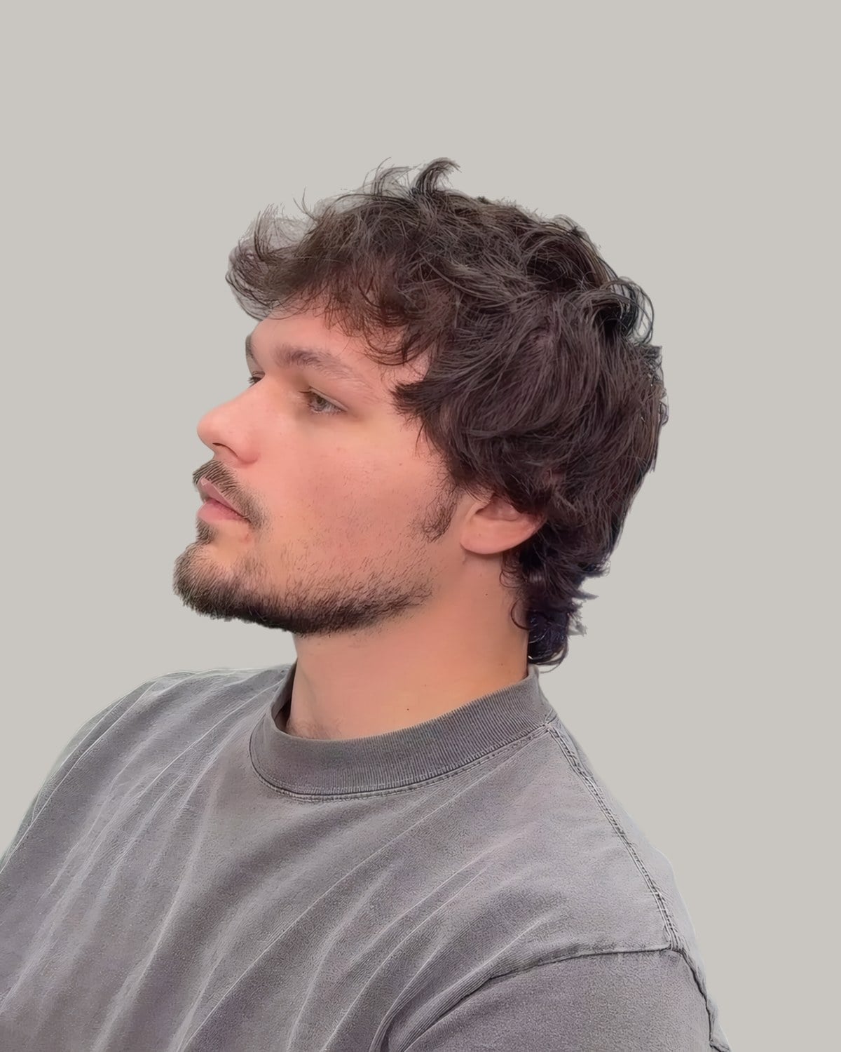 Bearded man with a messy wavy fringe, seen from the side