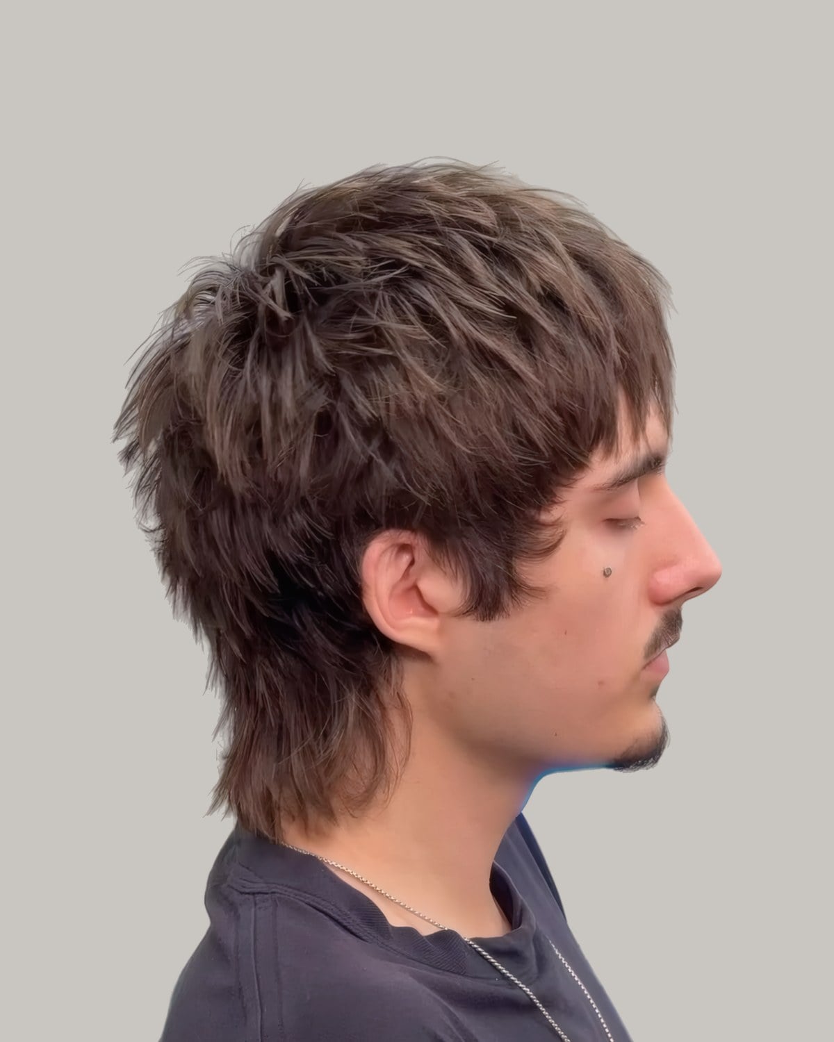 Man with a textured fringe mullet, seen in profile