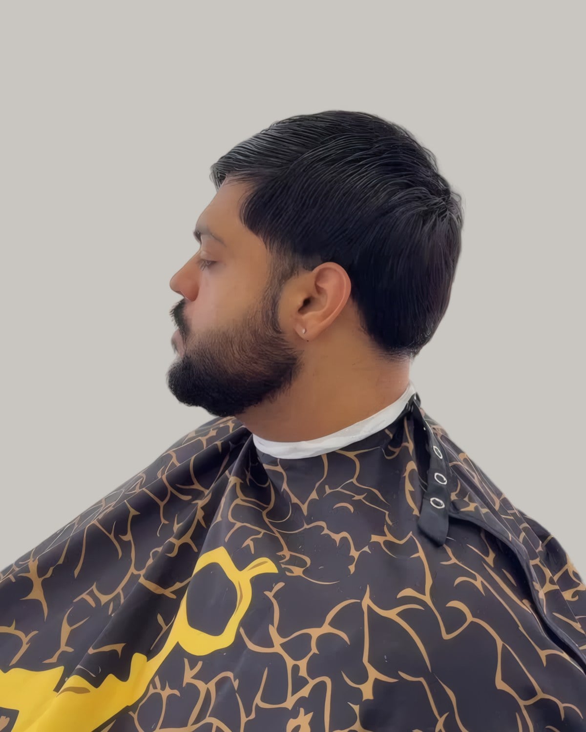 Bearded man with a short textured top brought forward, seen in profile