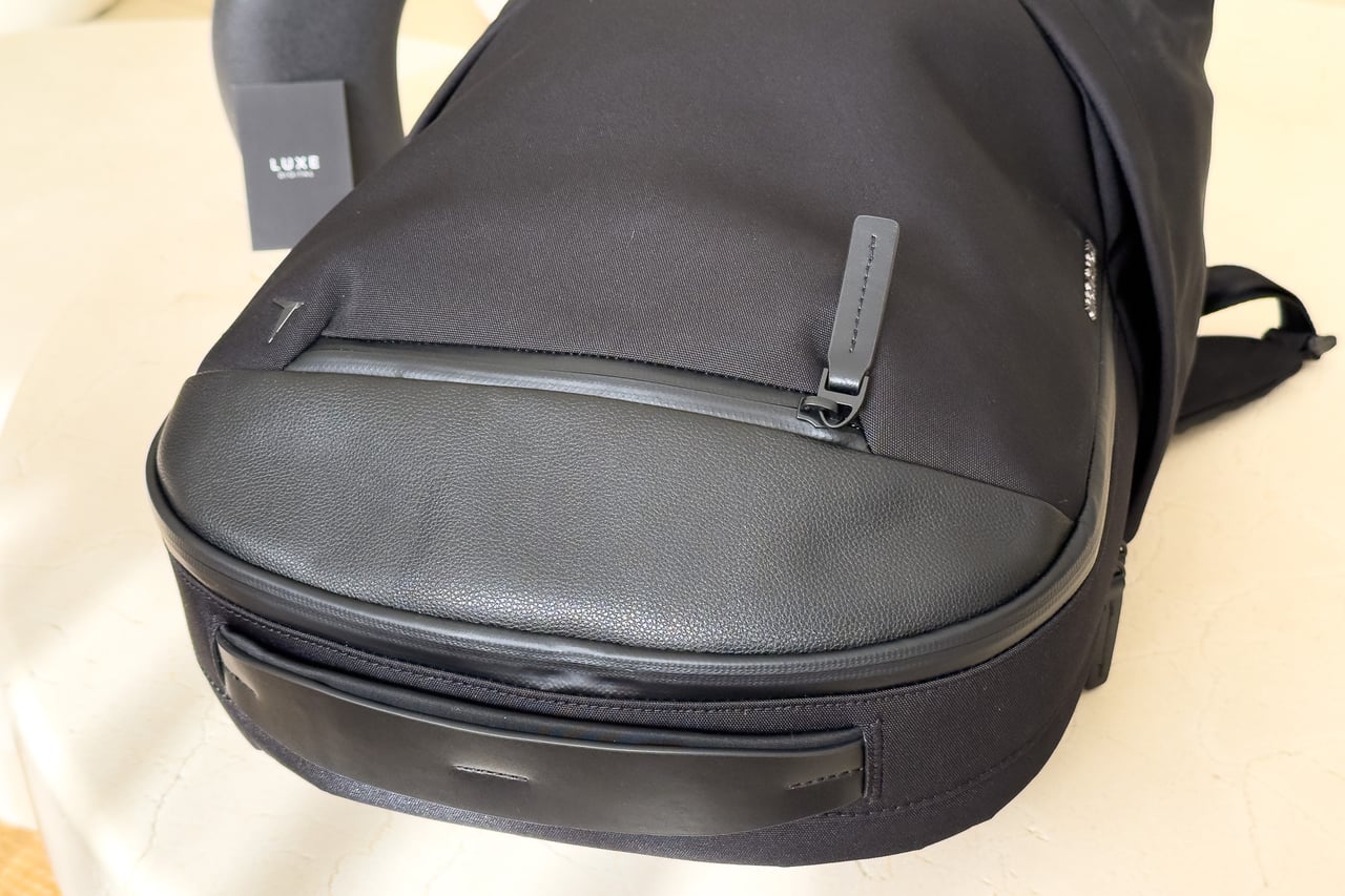 Front corner detail of the Troubadour Apex Backpack 4.0 showing its structured leather-trimmed base - Luxe Digital