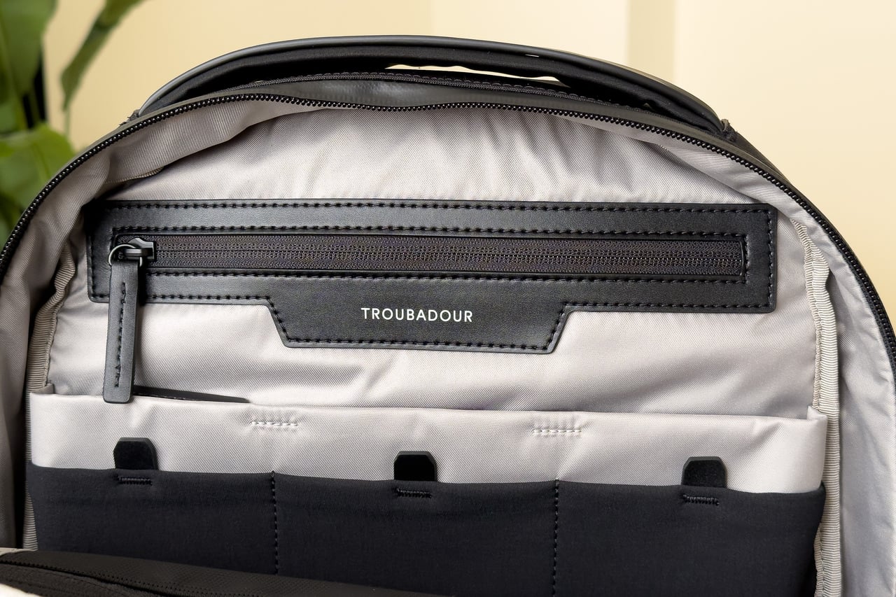 Close-up of the Troubadour Apex Backpack's interior zip pocket with vegan leather trim - Luxe Digital