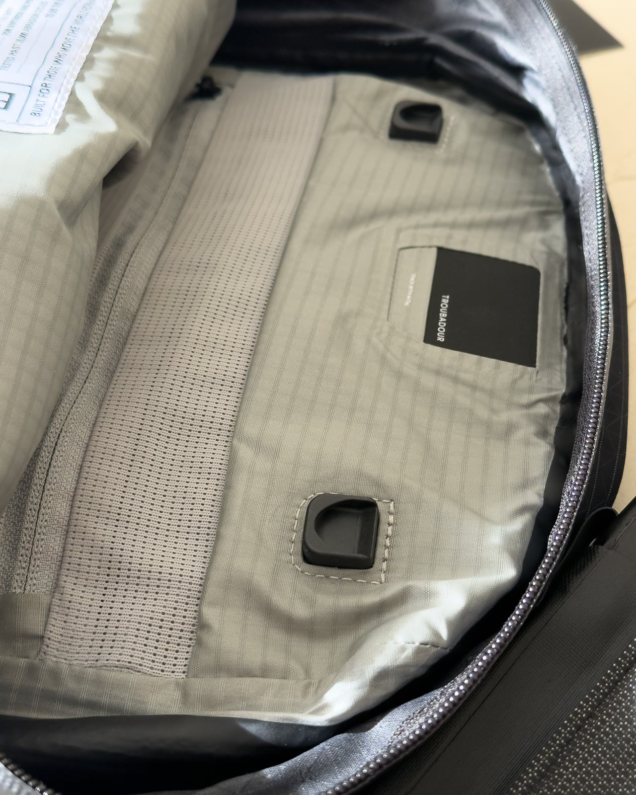 The magnetic clips that attach the DRYLINE COCOON laptop case to the Troubadour Elemental Backpack - Luxe Digital