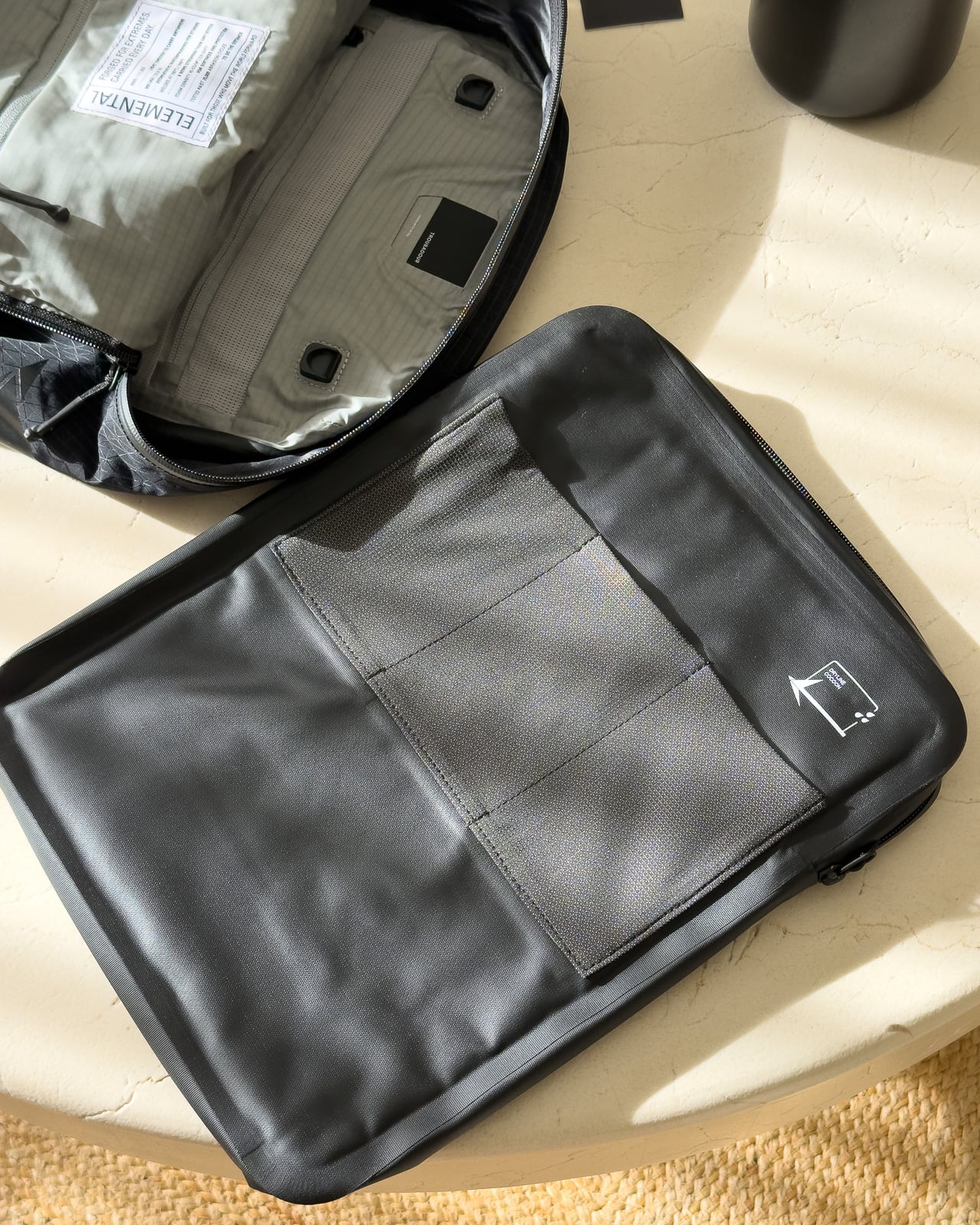 Troubadour Elemental Backpack's DRYLINE COCOON laptop case shown open next to the backpack - Luxe Digital