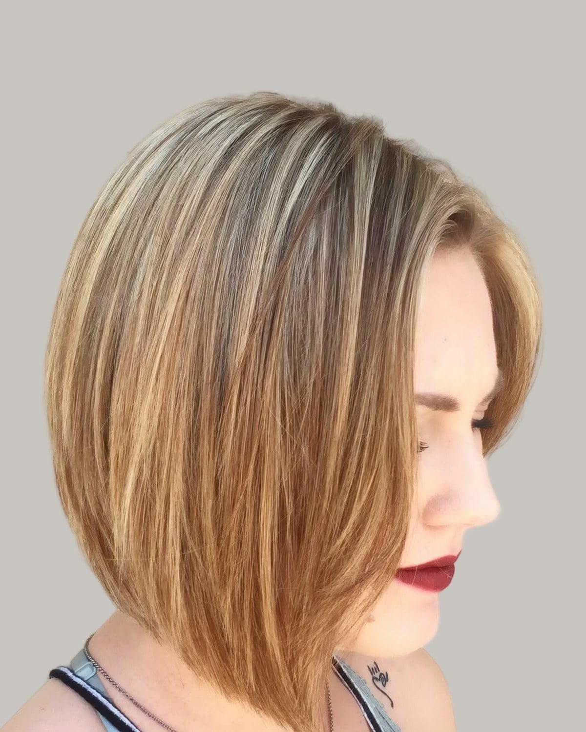 Woman with a golden-brown A-line bob, seen from the side