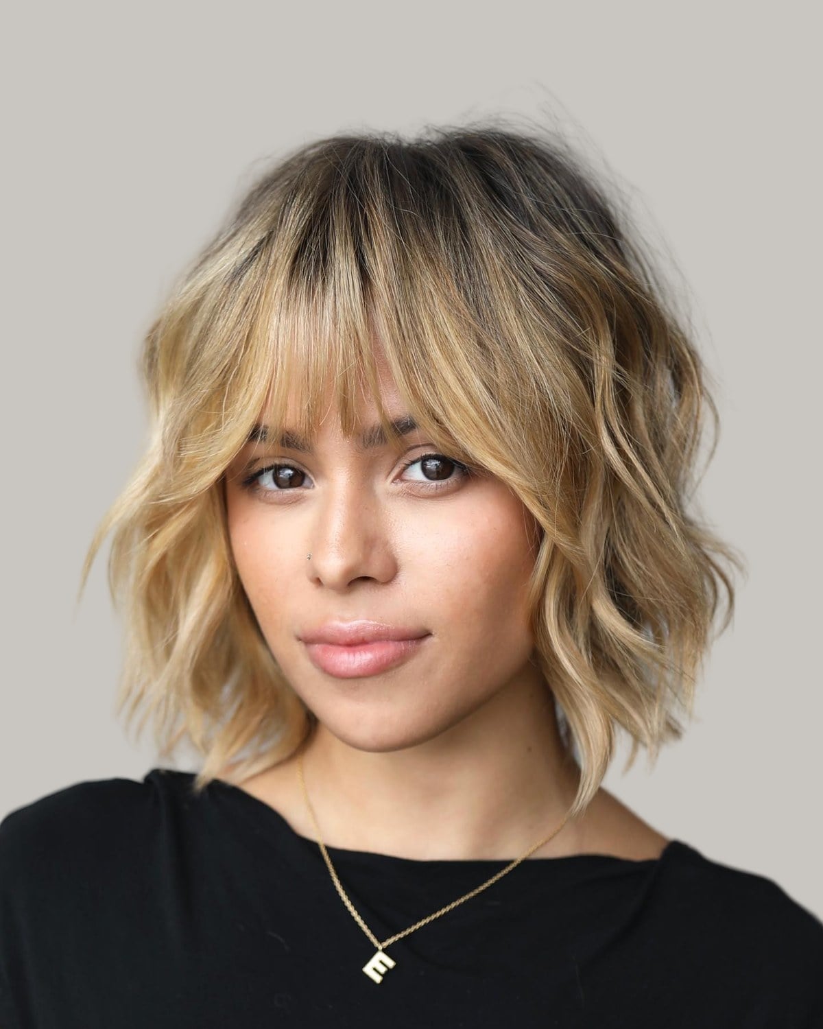 Woman with a wavy blonde bob and center-parted bangs, facing the camera
