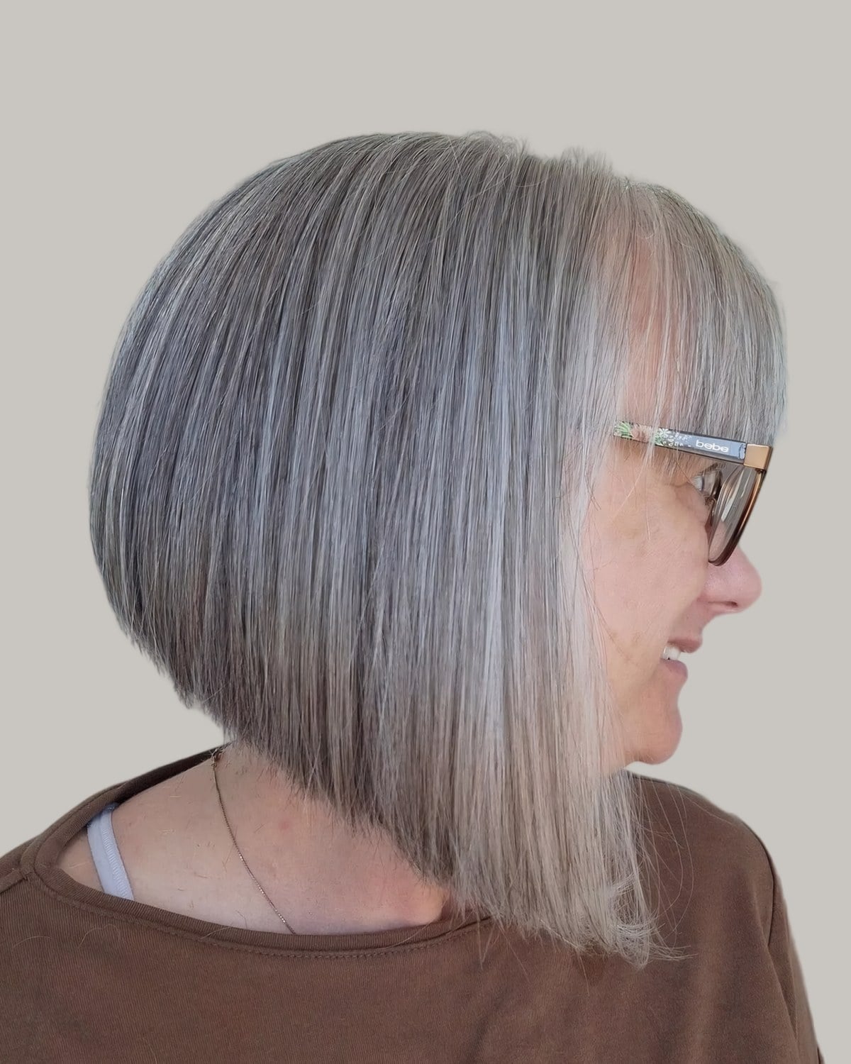 Woman with a gray A-line bob and glasses, seen from the side