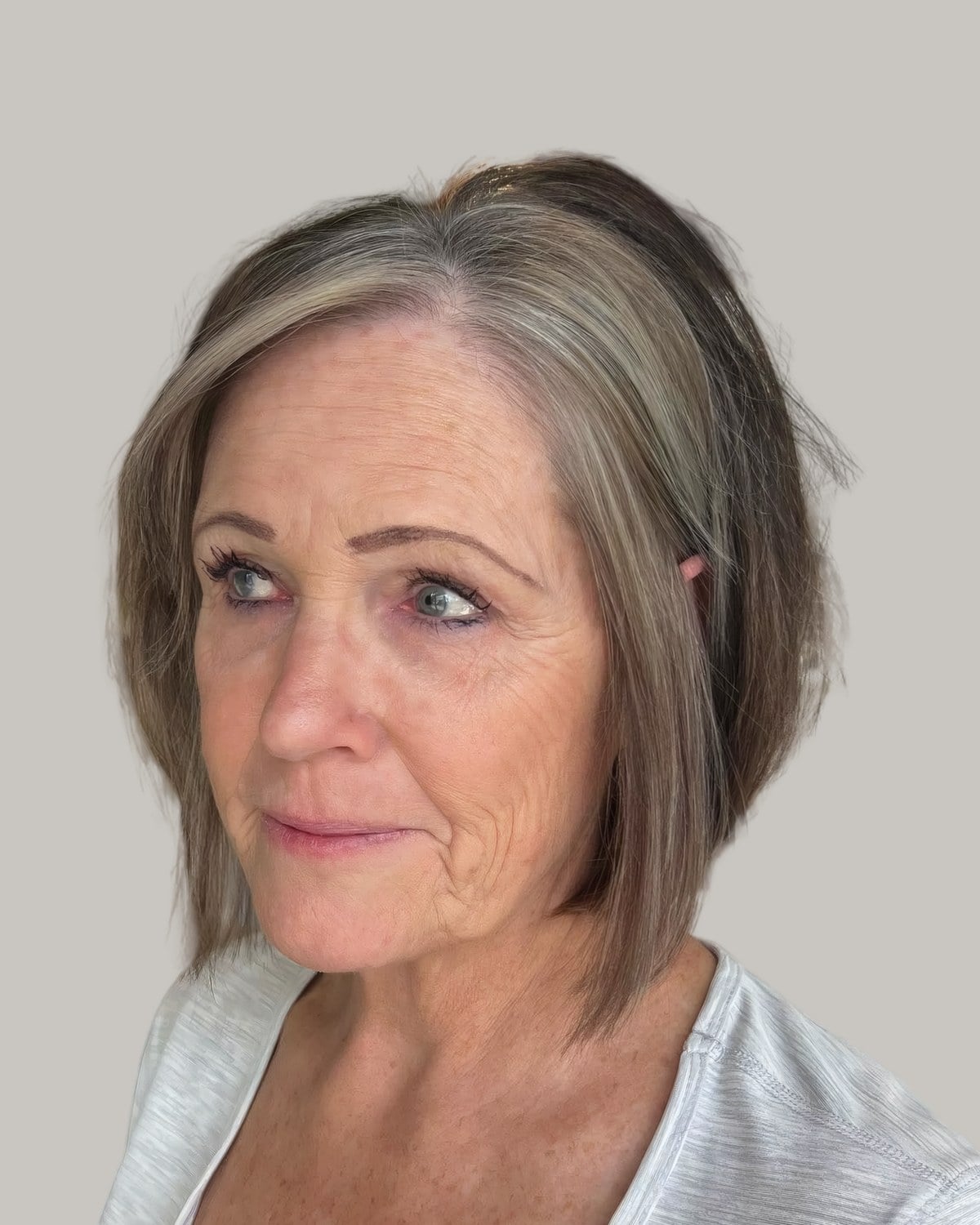 Older woman with a gray-brown chin-length bob, in three-quarter view