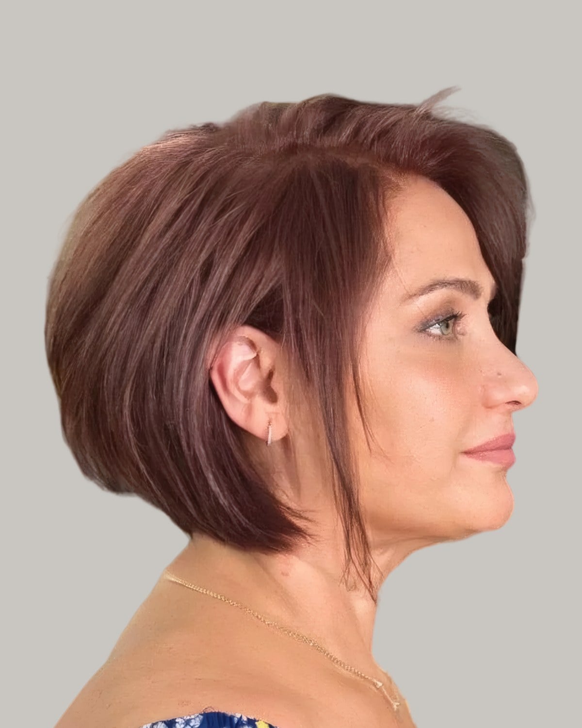 Older woman with an auburn inverted bob, seen in profile