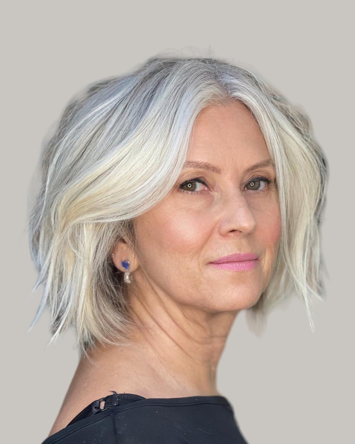 Woman with a silver-white textured bob and a side part, in three-quarter view