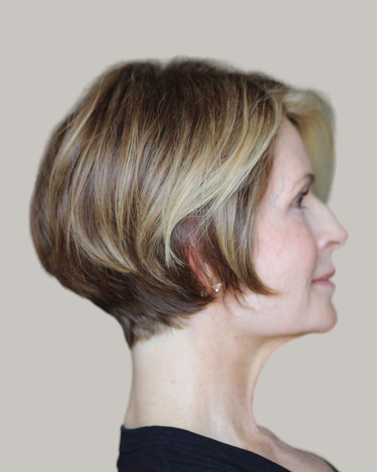 Older woman with a blonde stacked bob, seen in profile
