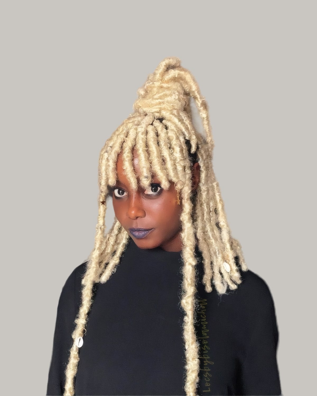 Woman with platinum faux locs, short bangs and the top pulled up