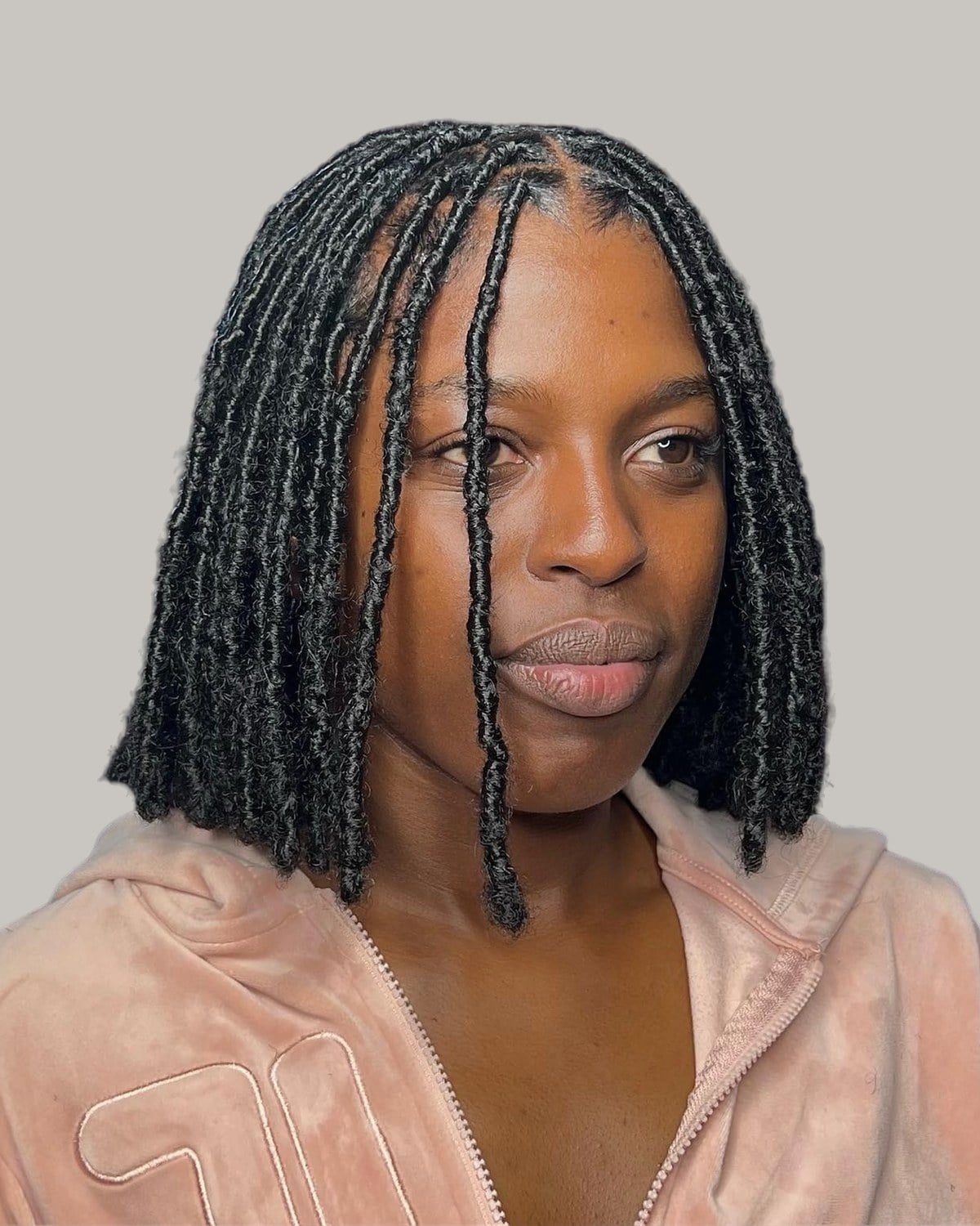 Woman with sleek jaw-length faux locs and a center part