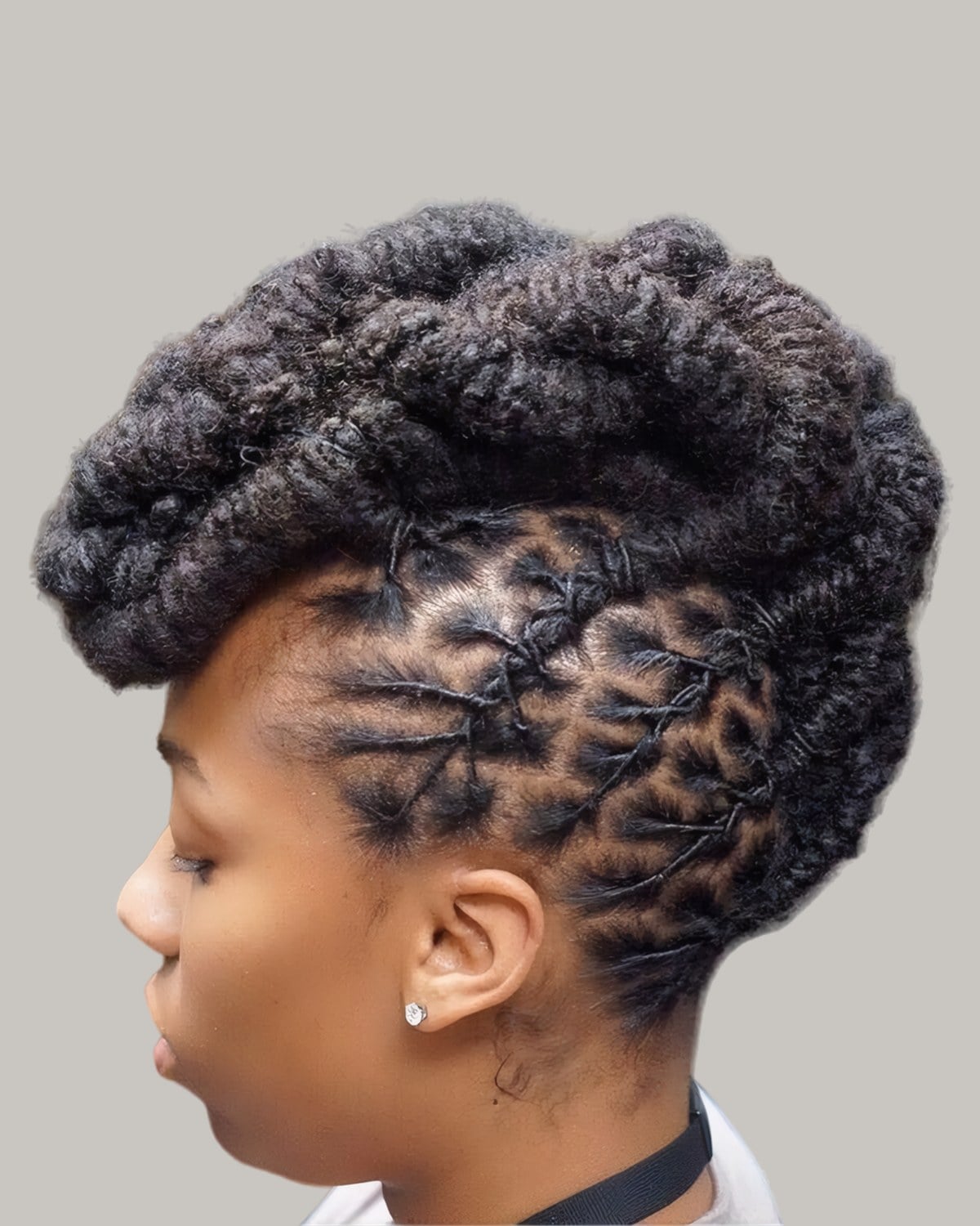 Woman with locs twisted up into a sculpted high top, in profile