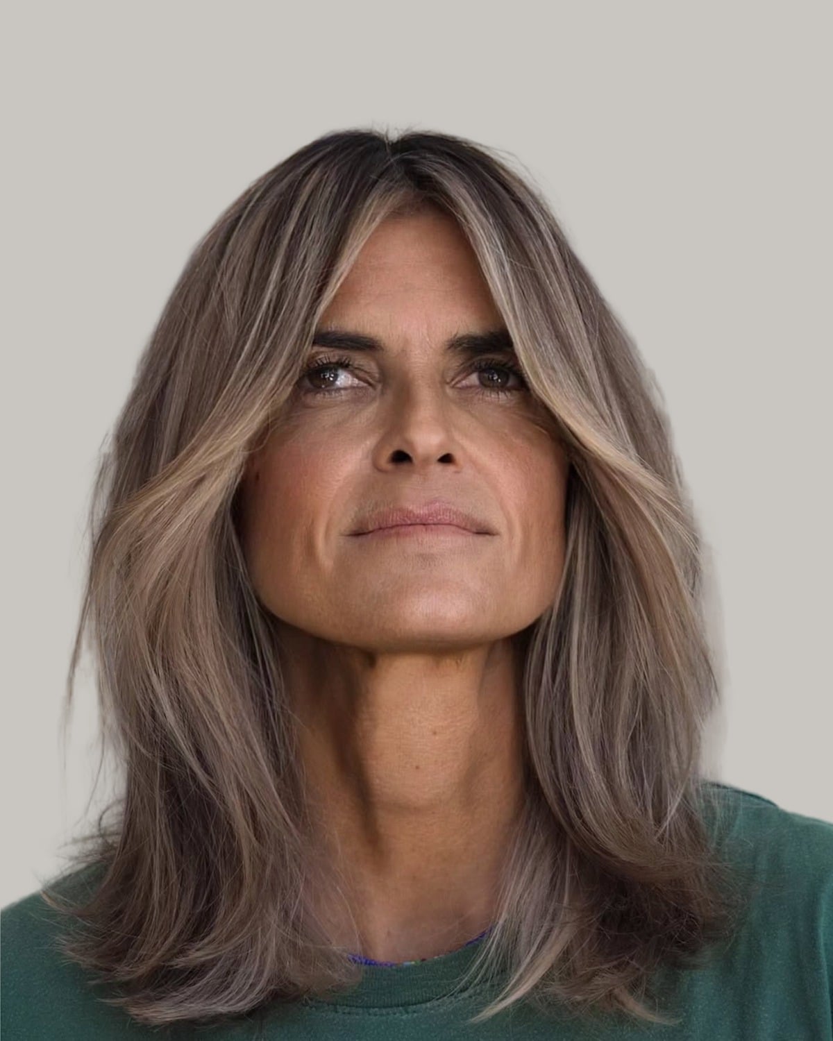 Woman with long layered hair and curtain bangs, looking up