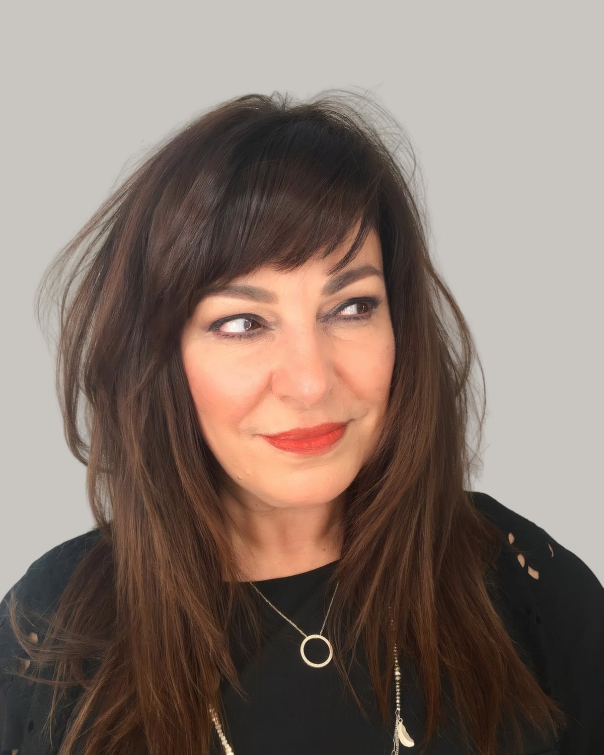 Woman with long dark layers and a full fringe