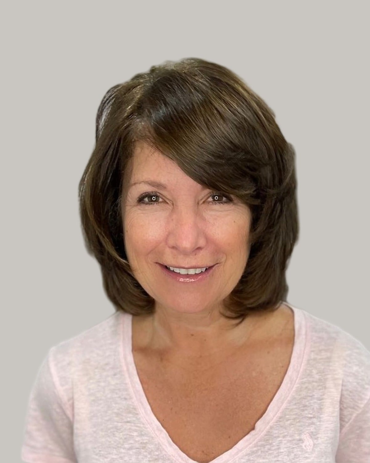 Smiling woman with a rounded brown bob and side-swept bangs
