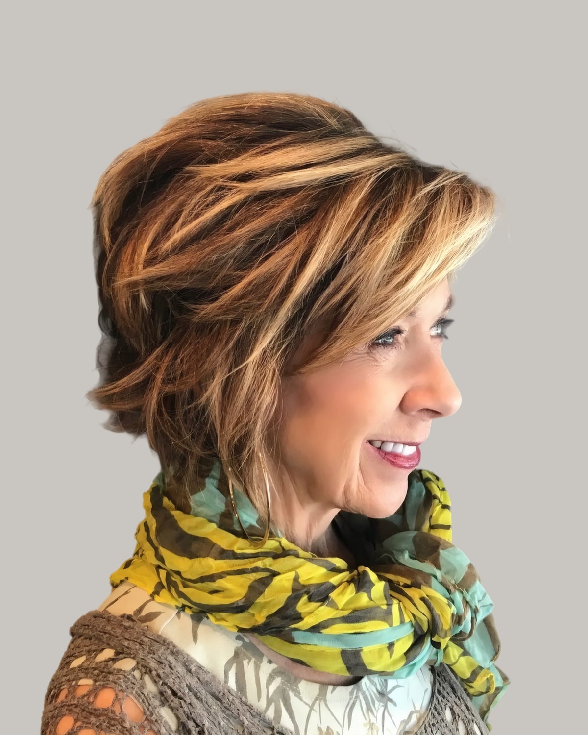 Smiling woman with a short multi-tone shag and a silk scarf