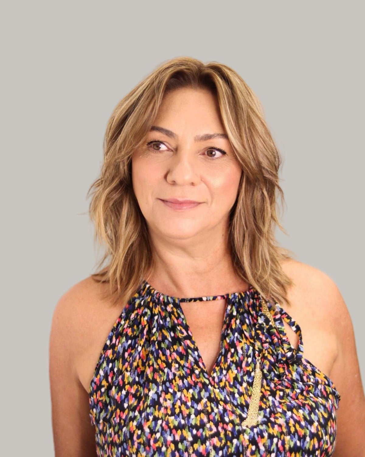 Woman with wavy caramel hair past the shoulders, face-framing layers at the front