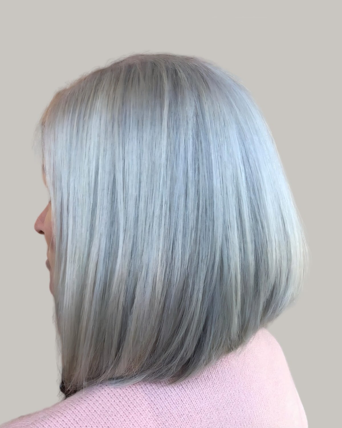 Woman with a blunt silver cut to the shoulders, seen from behind
