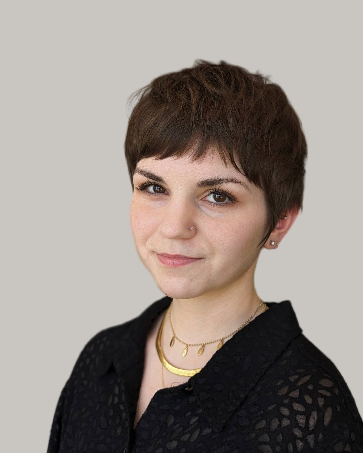 Woman with a short, brown layered pixie and a piecey fringe