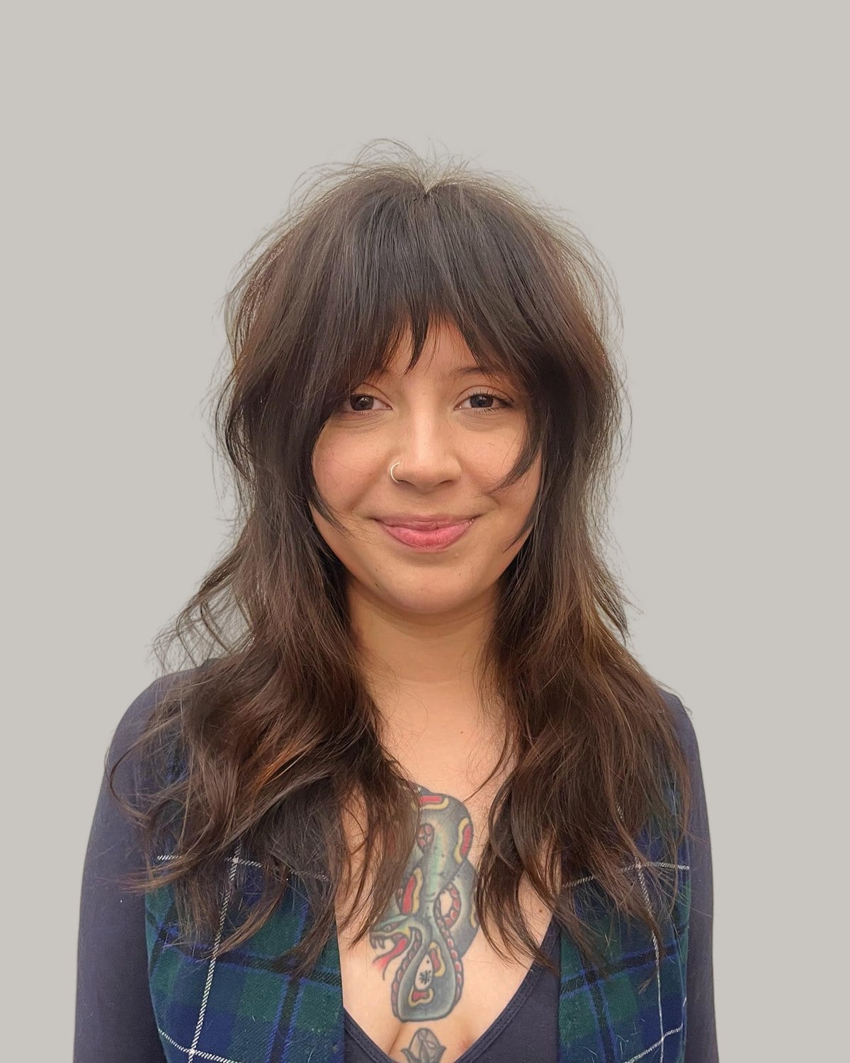 Smiling woman with a long brown shag and a wispy fringe
