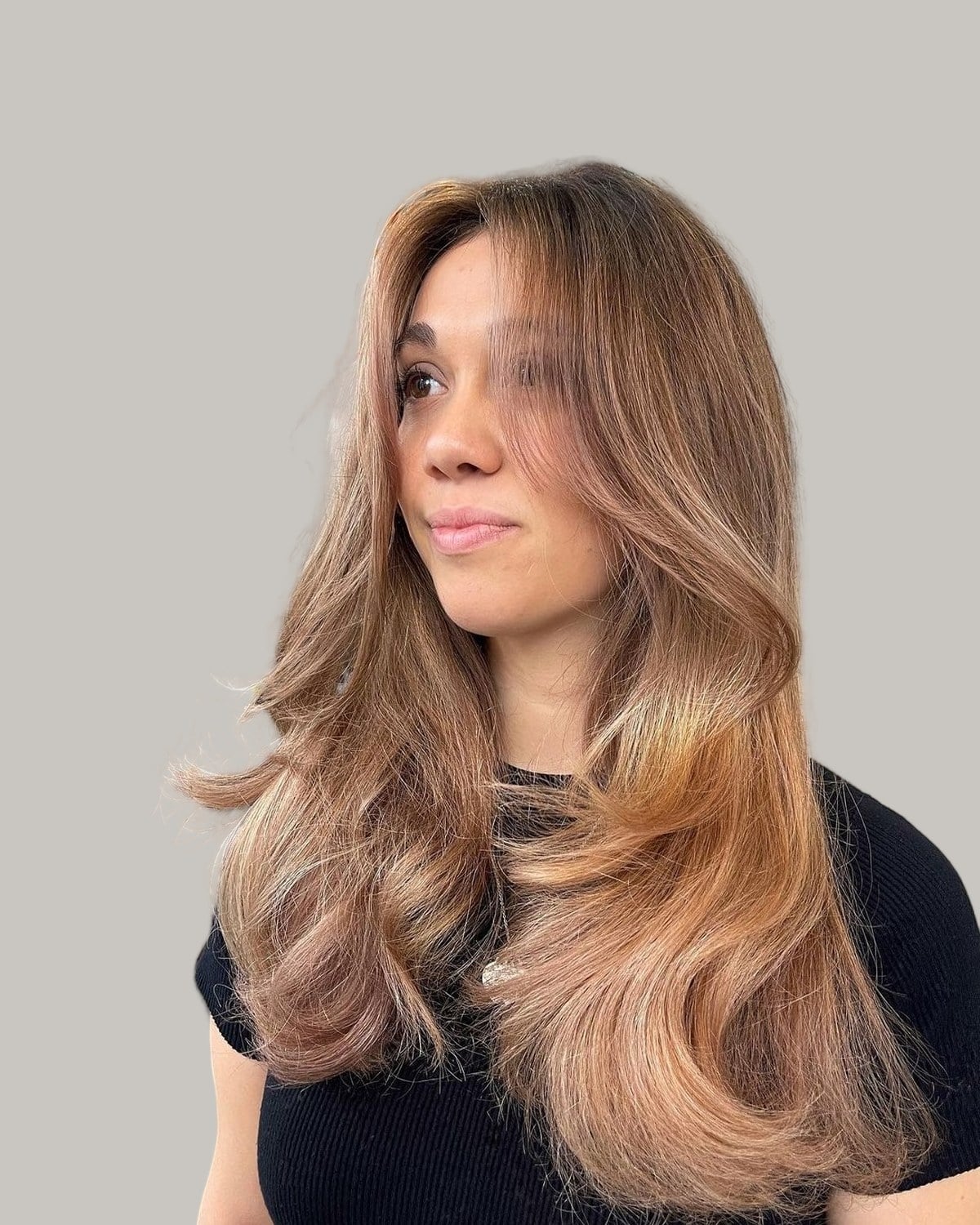 Woman with long caramel hair in big bends, looking away