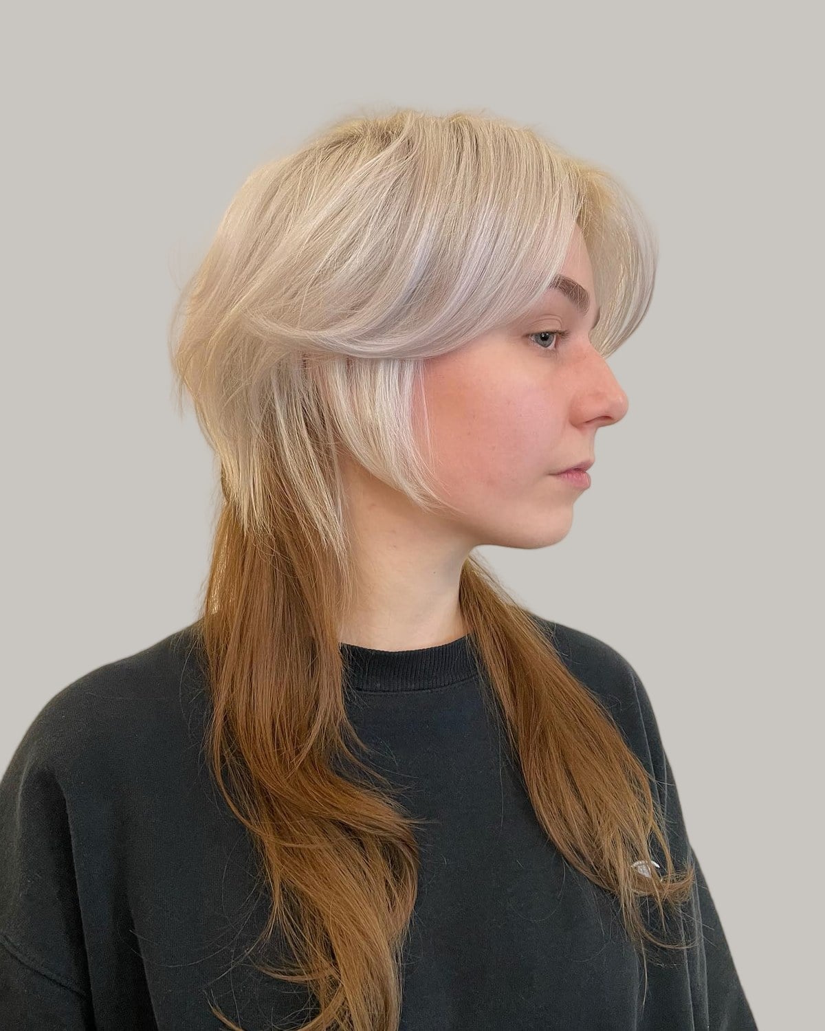 Woman in profile with a platinum jellyfish haircut over long copper lengths