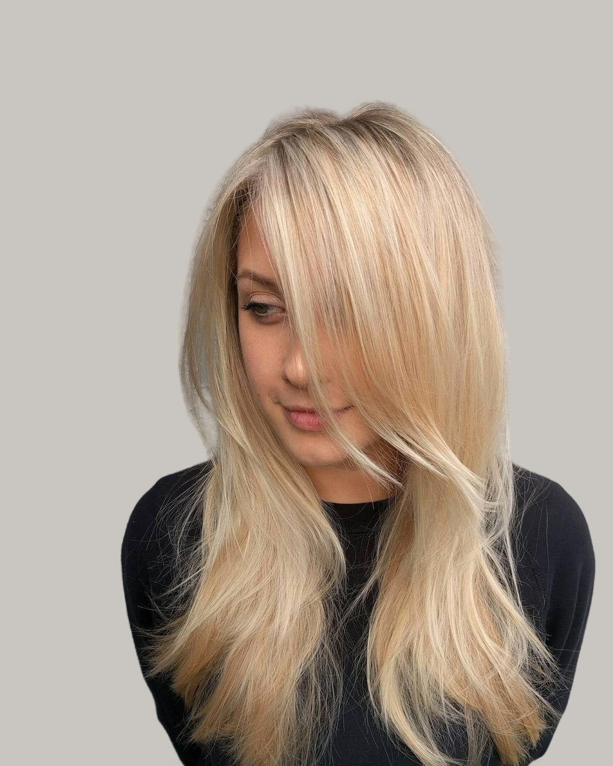 Woman with long, straight blonde hair and a long fringe swept across one eye