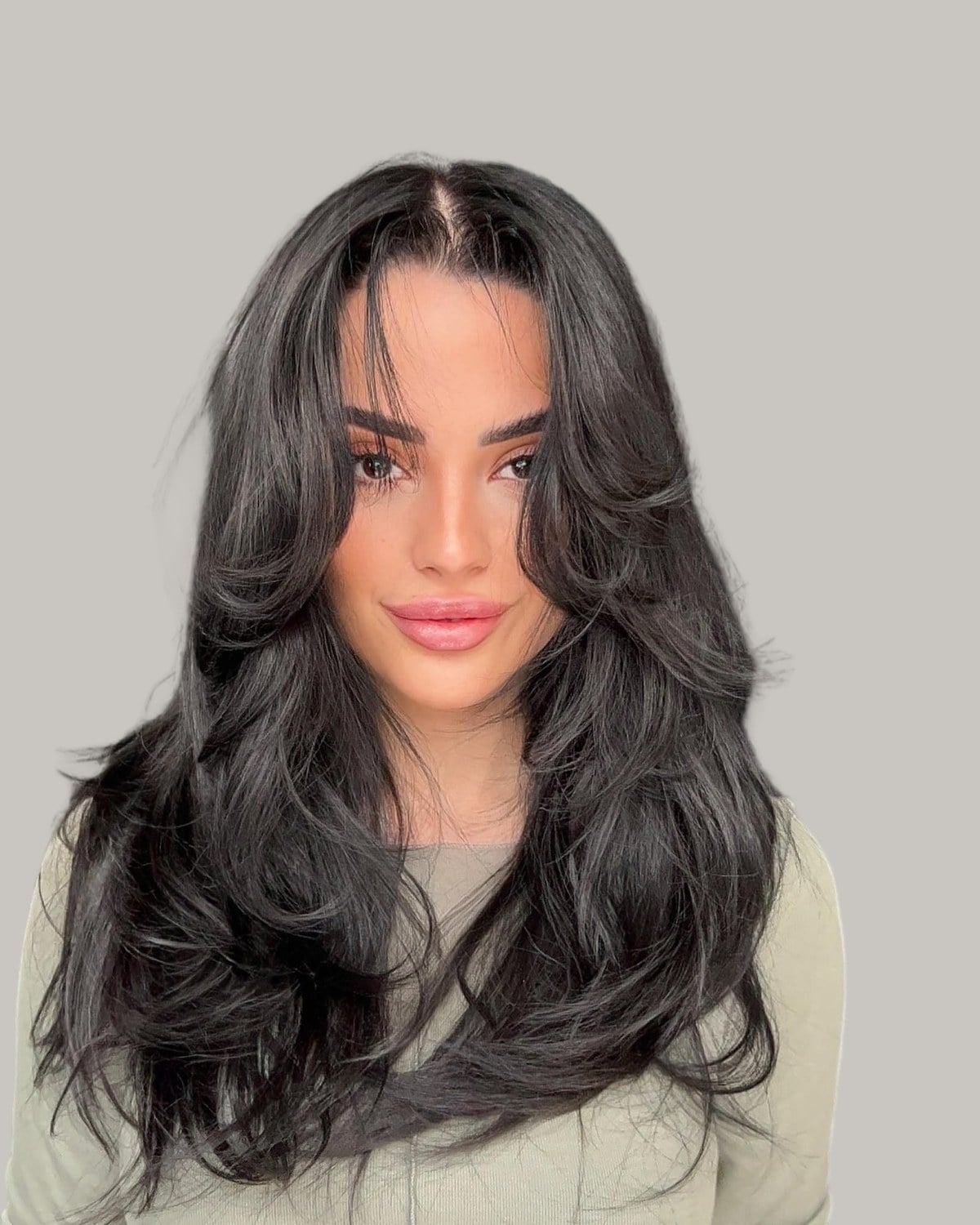 Woman with long, thick, glossy black hair in big layered bends