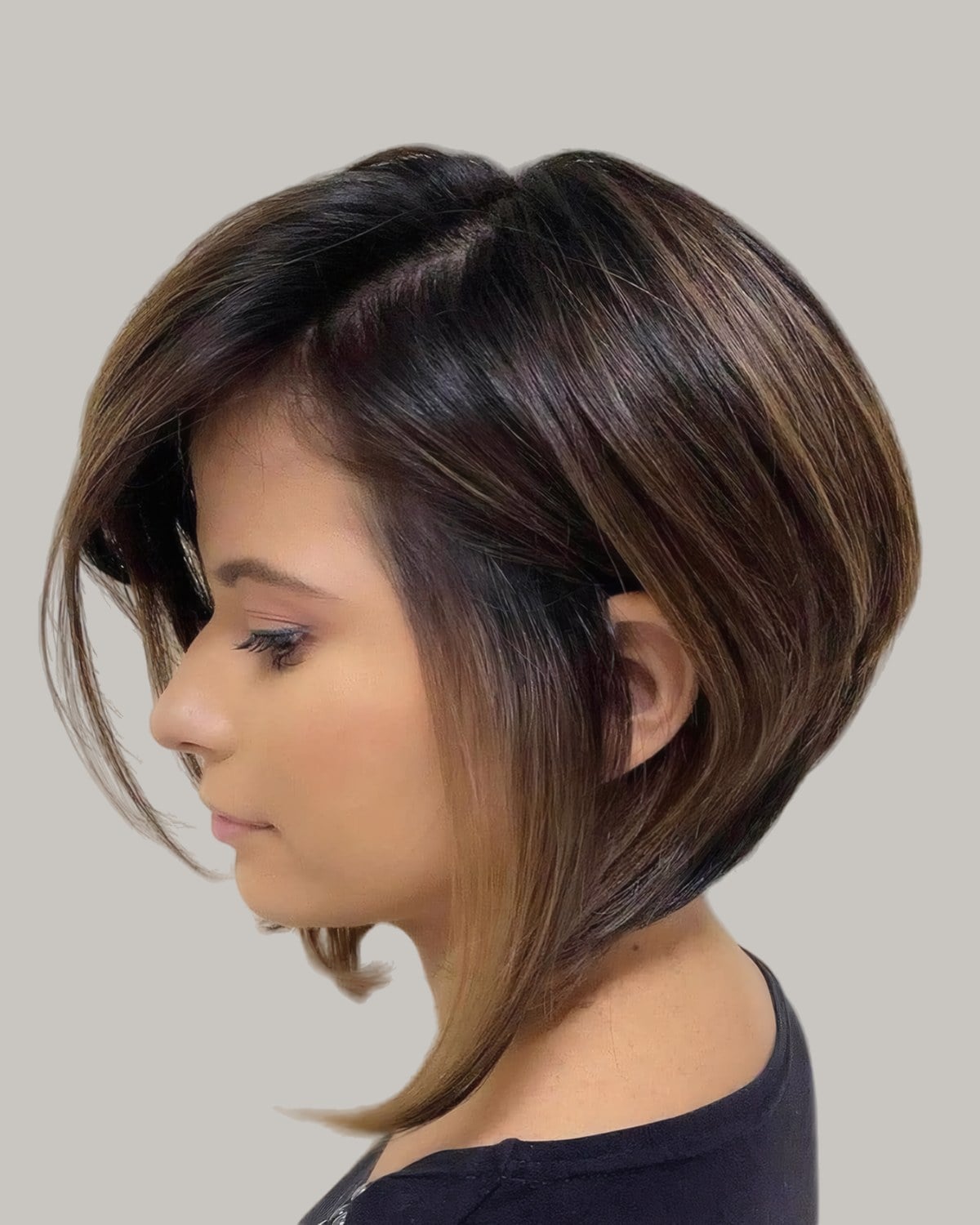 Woman with a dark inverted bob and long front pieces, in profile