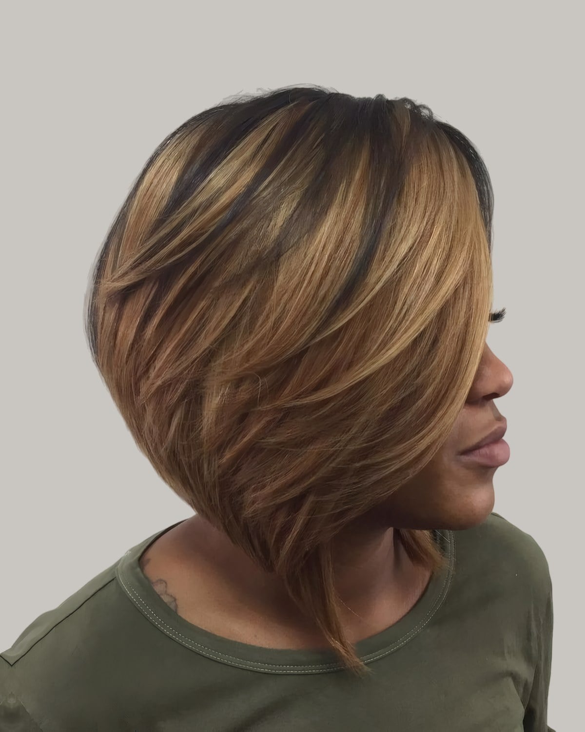 Woman with a highlighted bob and long feathered front, in profile