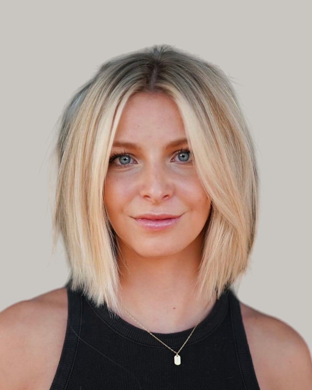 Smiling woman with a straight sandy blonde bob and a center part