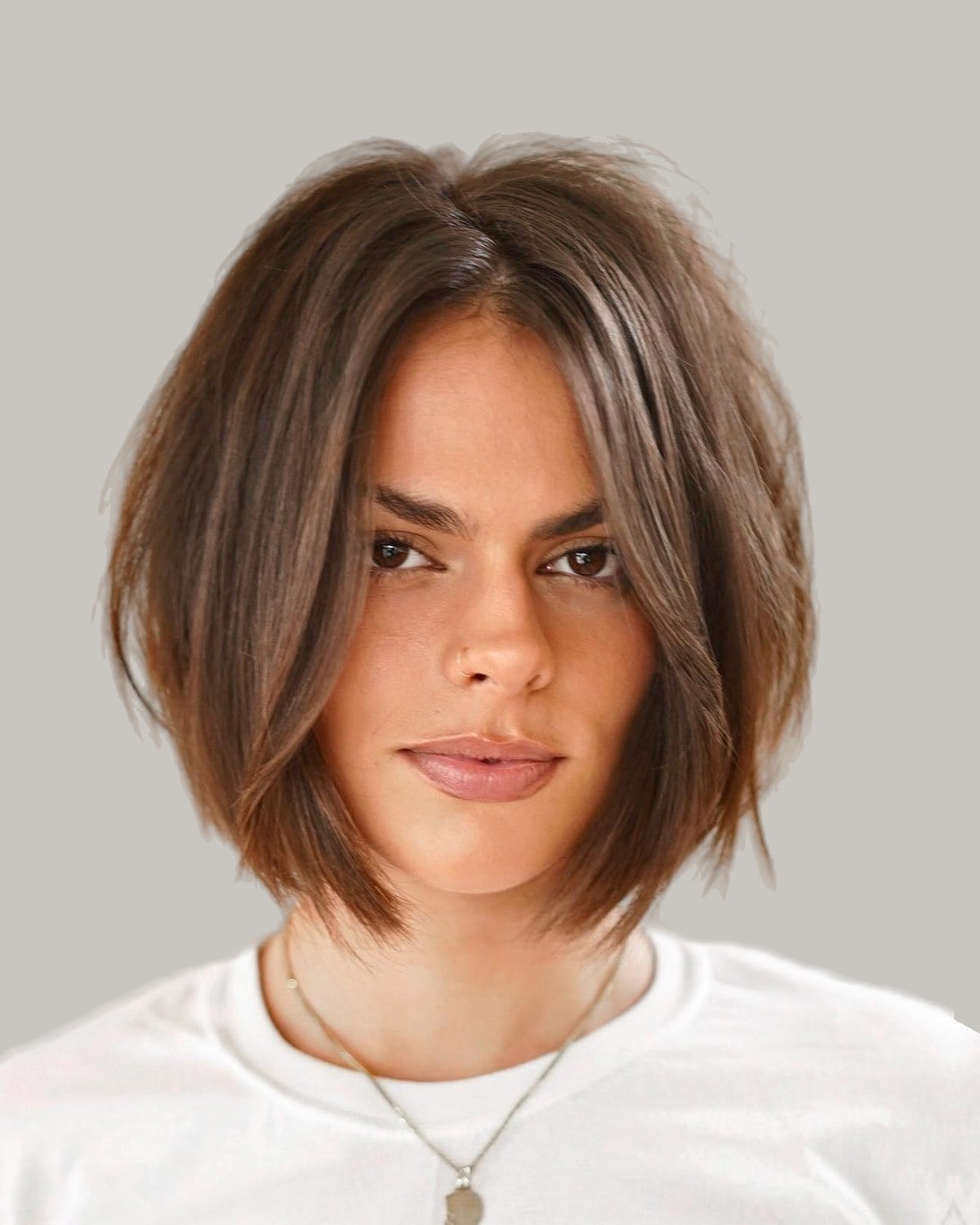 Woman with a brown chin-length bob parted in the middle, looking straight ahead