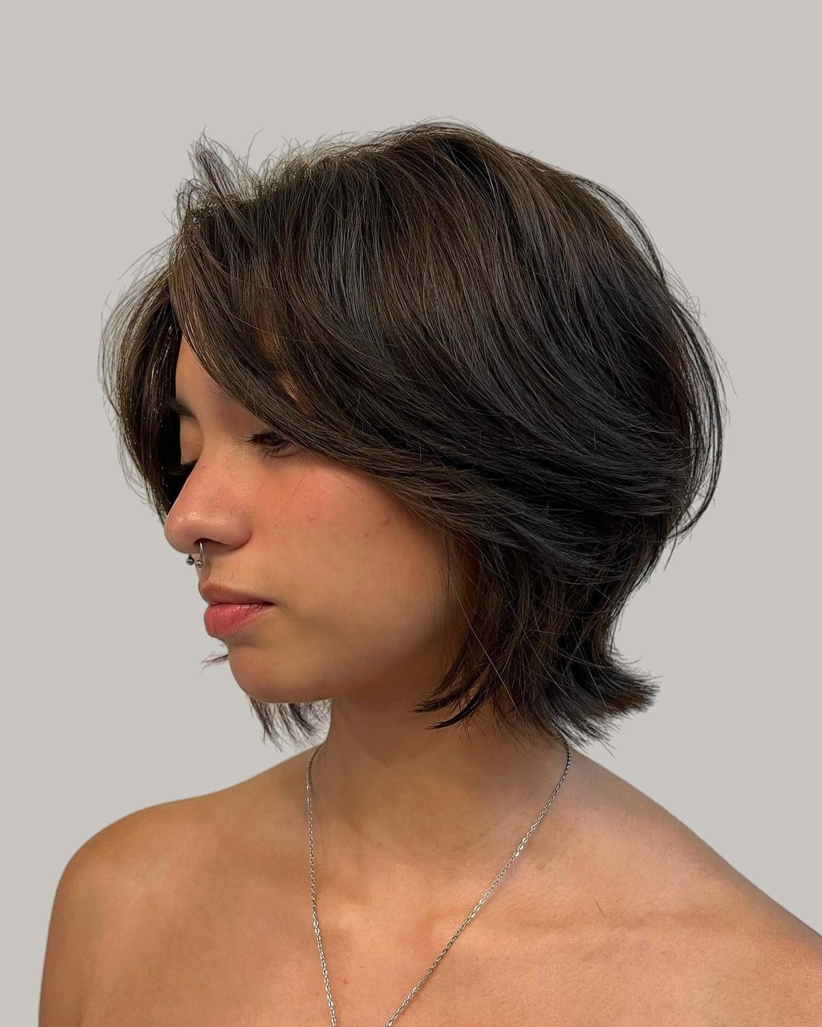Woman with a brown bob and side bangs, looking down